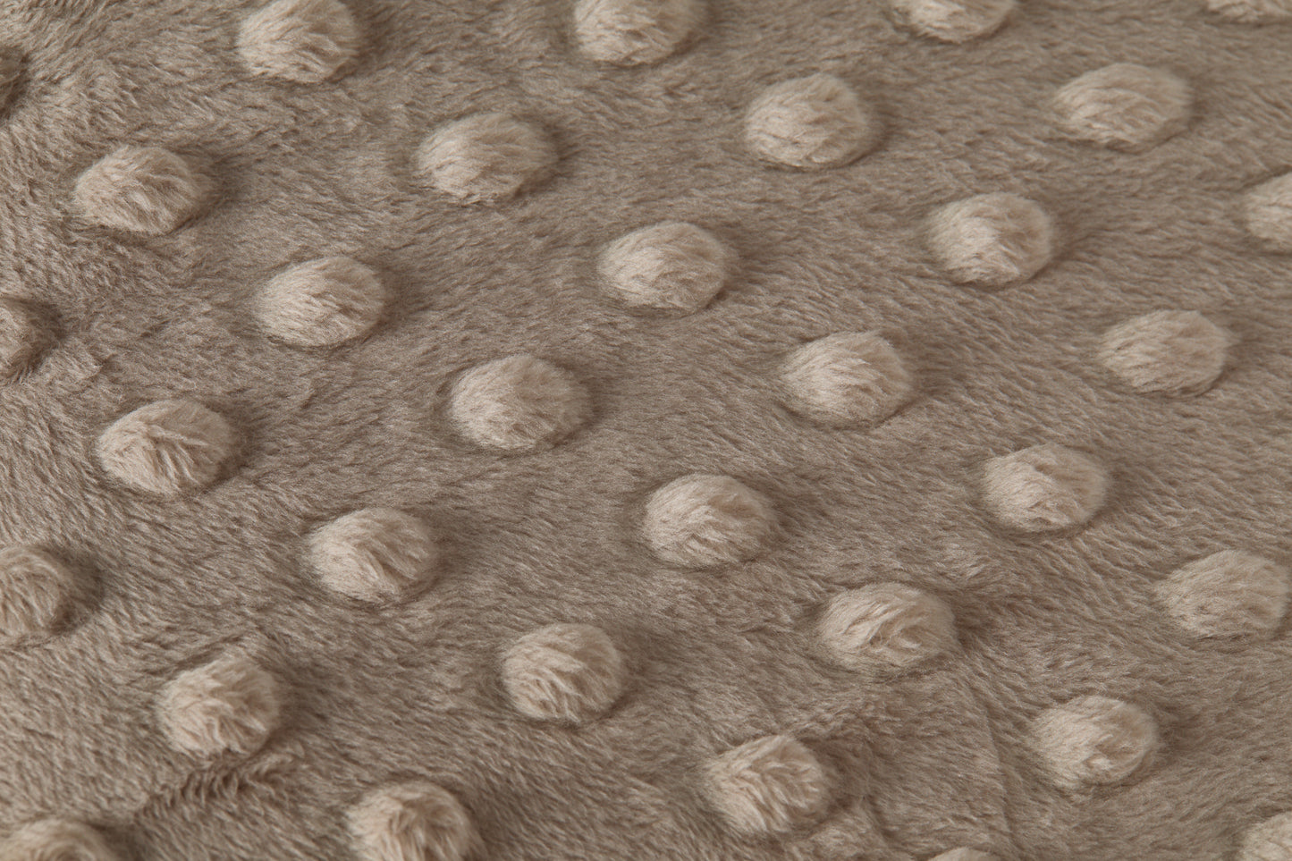 Close-up of a textured taupe fabric with raised dots