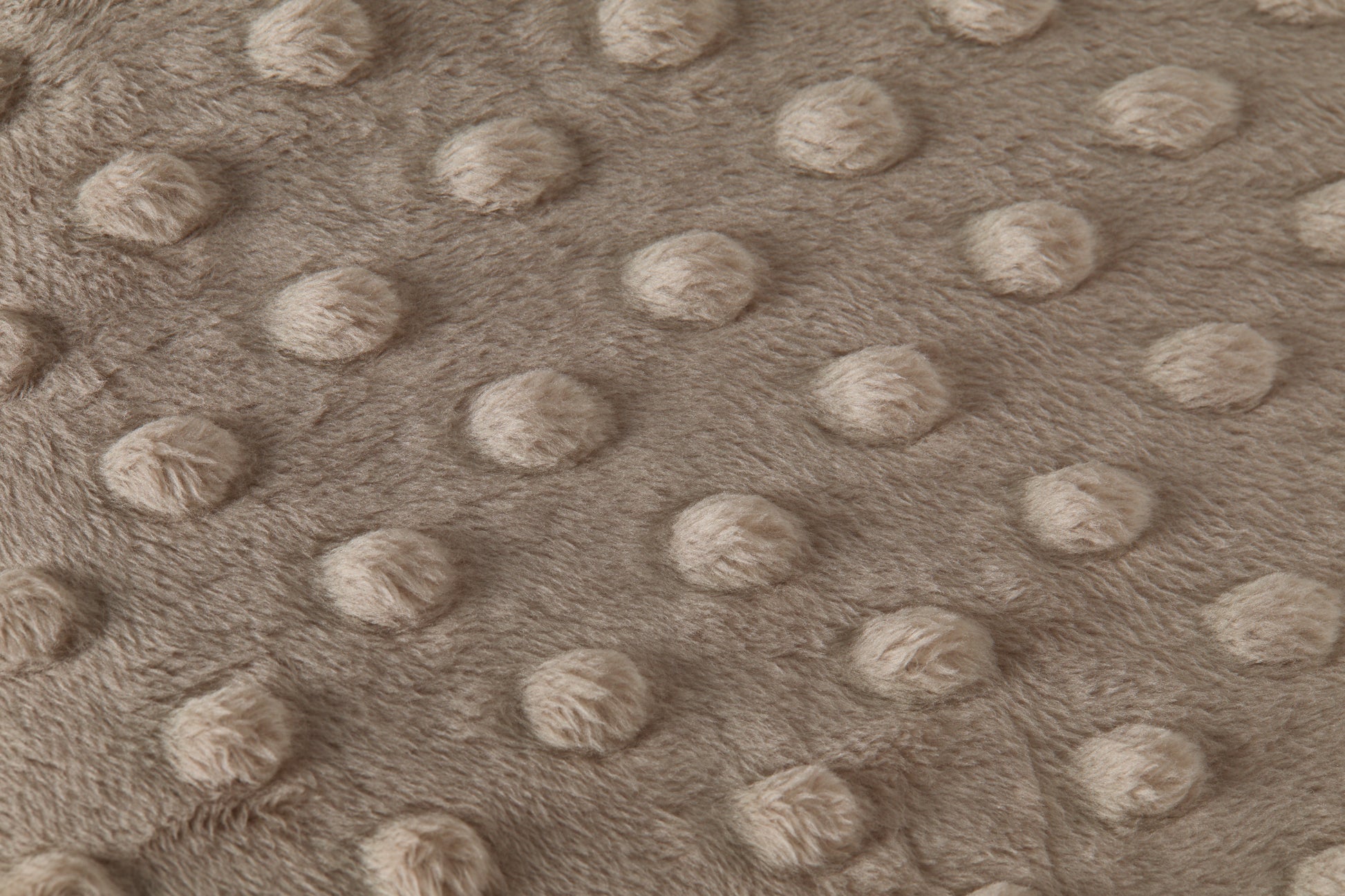 Close-up of a textured taupe fabric with raised dots